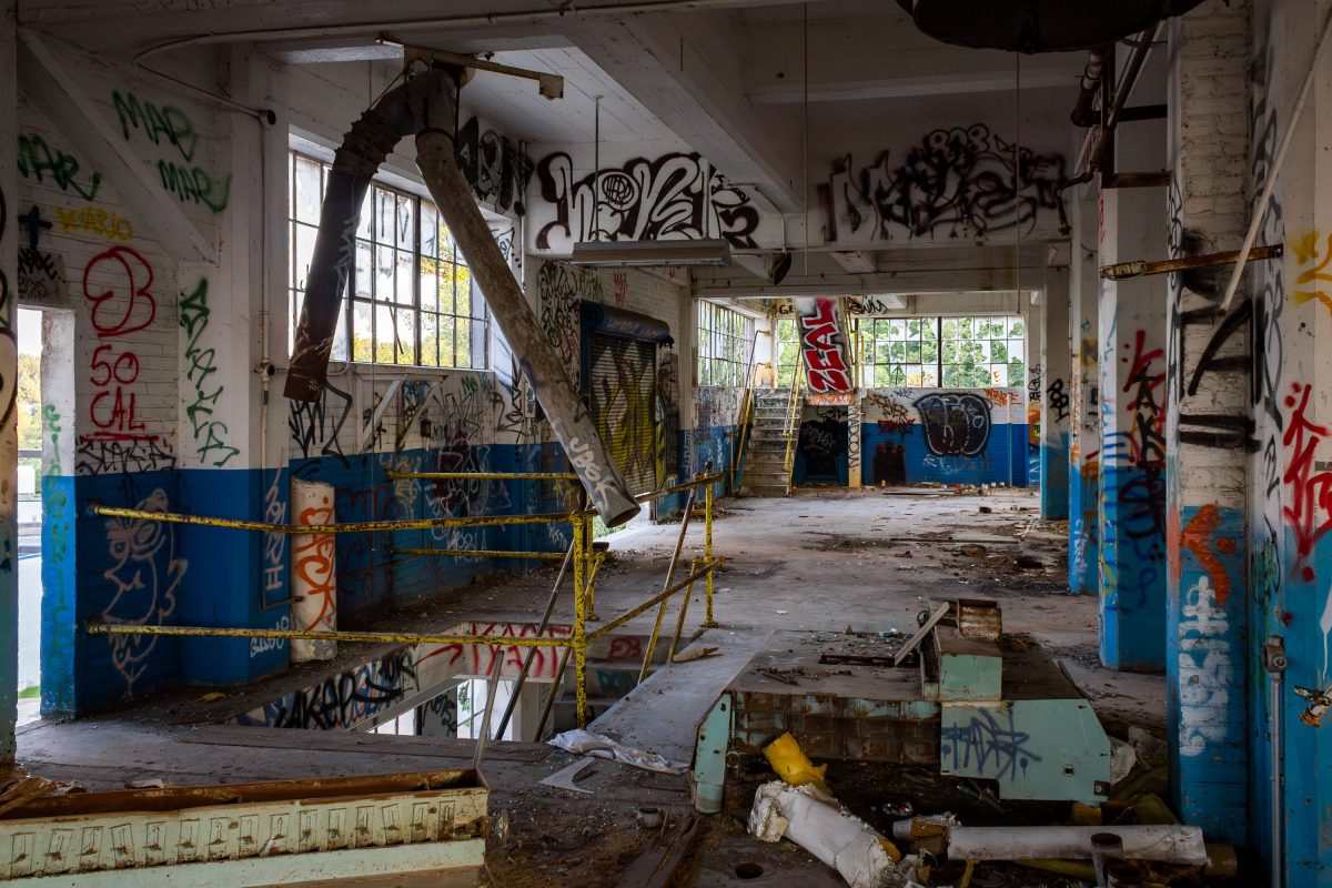 Abandoned Fruen Mill interior in Minneapolis with graffiti-covered walls, rusted equipment, and deteriorating industrial