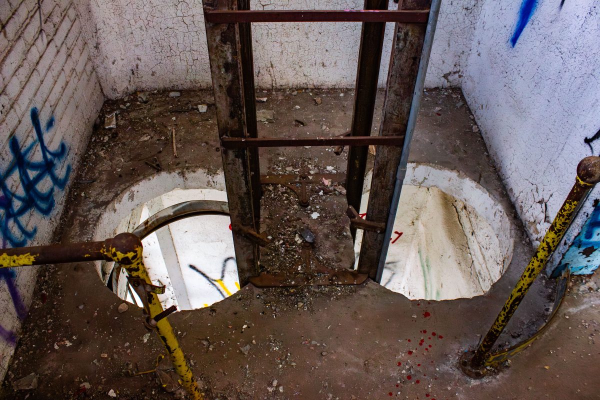 Deteriorating basement room in the abandoned Fruen Mill grain processing facility in Minneapolis with exposed pipe and debris.