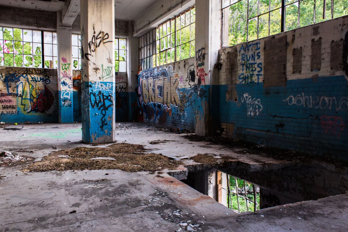 Abandoned Fruen Mill interior in Minneapolis with graffiti-covered walls, concrete support pillars, and deteriorating industrial