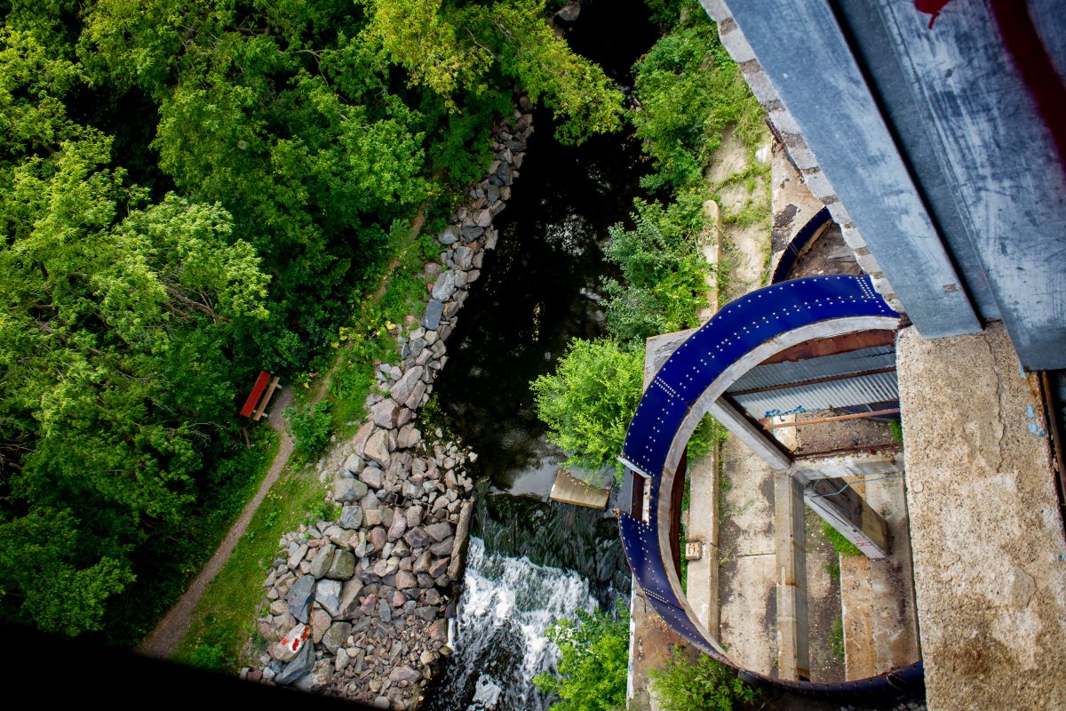 Aerial view of Fruen Mill grain processing facility along Bassett Creek in Minneapolis with forested banks.