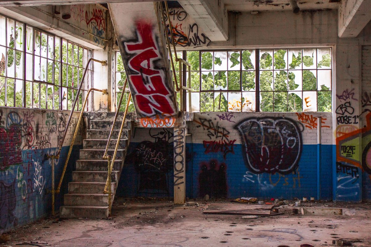 Abandoned Fruen Mill interior in Minneapolis with graffiti-covered brick walls, broken windows, and deteriorating industrial