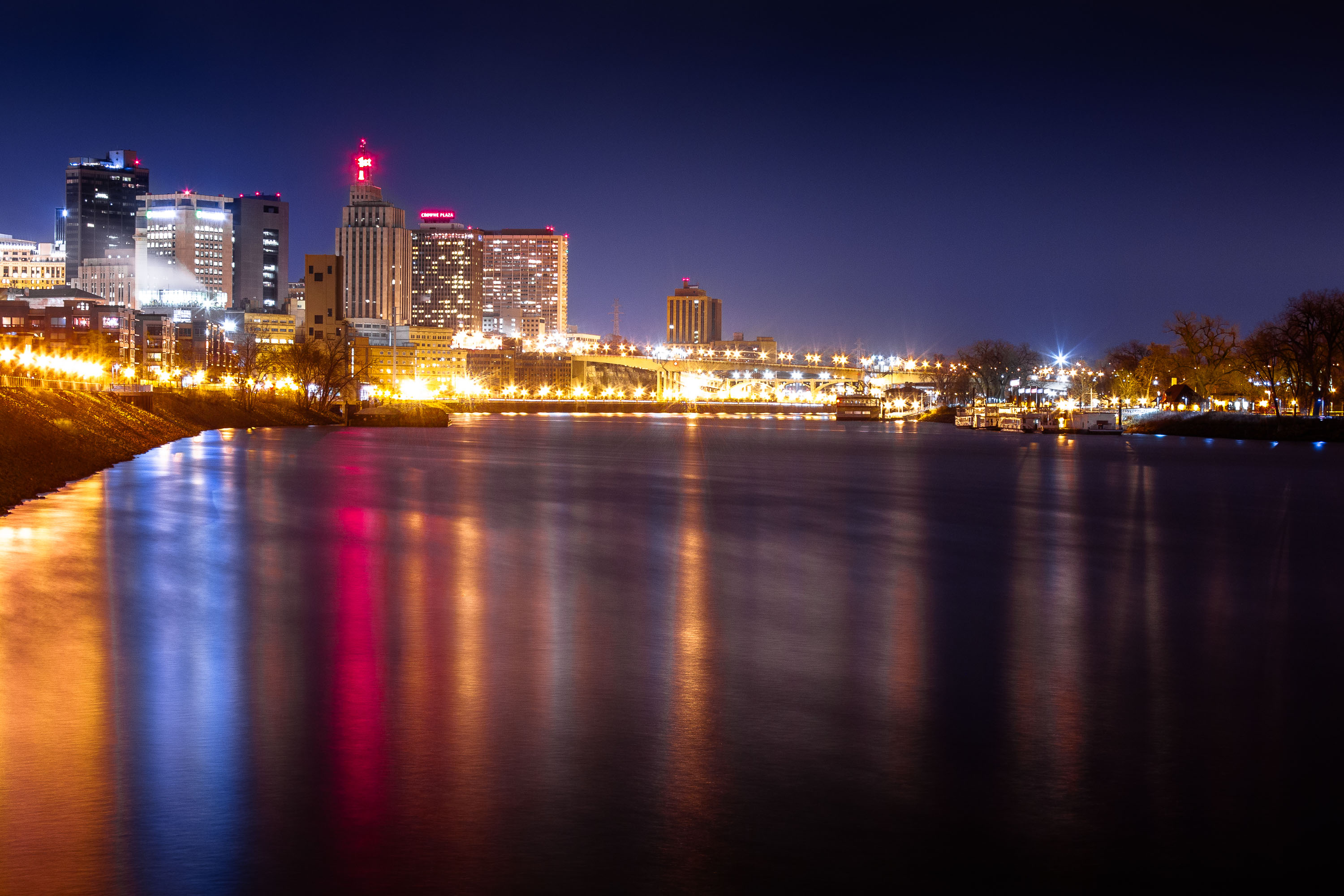St. Paul skyline at night illuminated above the Mississippi River.