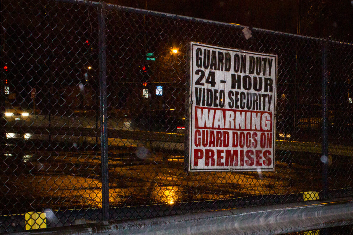 A security sign warning of video security, guards and guard dogs at the abandoned Brach's candy factory in Chicago. The factory has since been demolished and replaced with a parking lot.