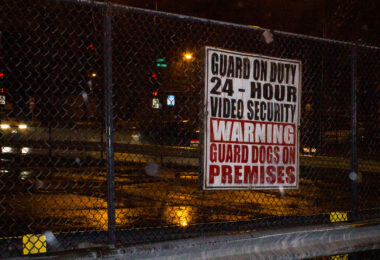 A security sign warning of video security, guards and guard dogs at the abandoned Brach's candy factory in Chicago. The factory has since been demolished and replaced with a parking lot.