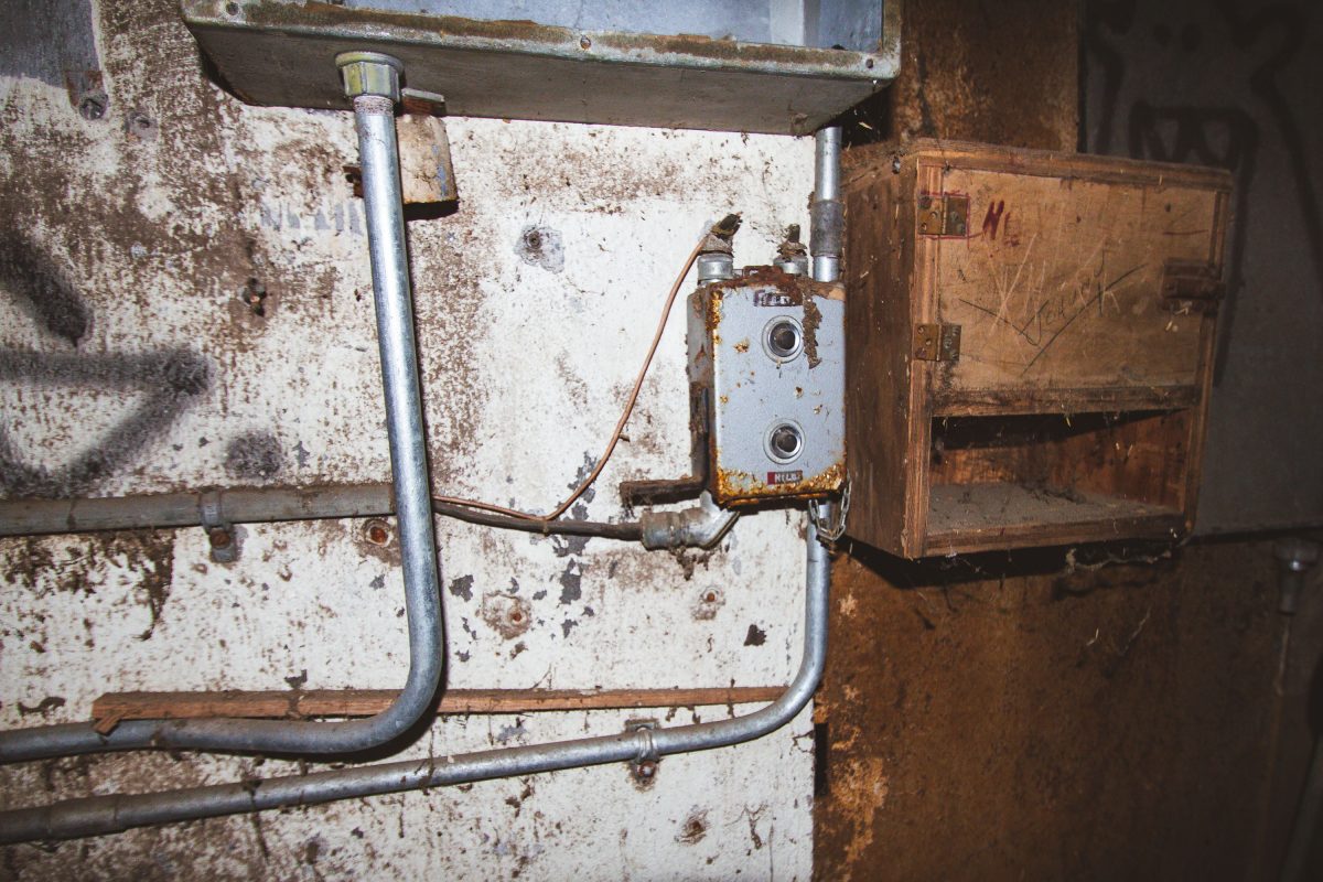 Corroded electrical switch and wiring on a deteriorating wall inside the abandoned Fruen Mill in Minneapolis.