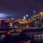 Downtown Minneapolis as seen from across the Mississippi River in 2013. The former Minnesota Vikings Stadium, the Metrodome, on the left side of the frame. The stadium has since been replaced by US Bank Stadium.
