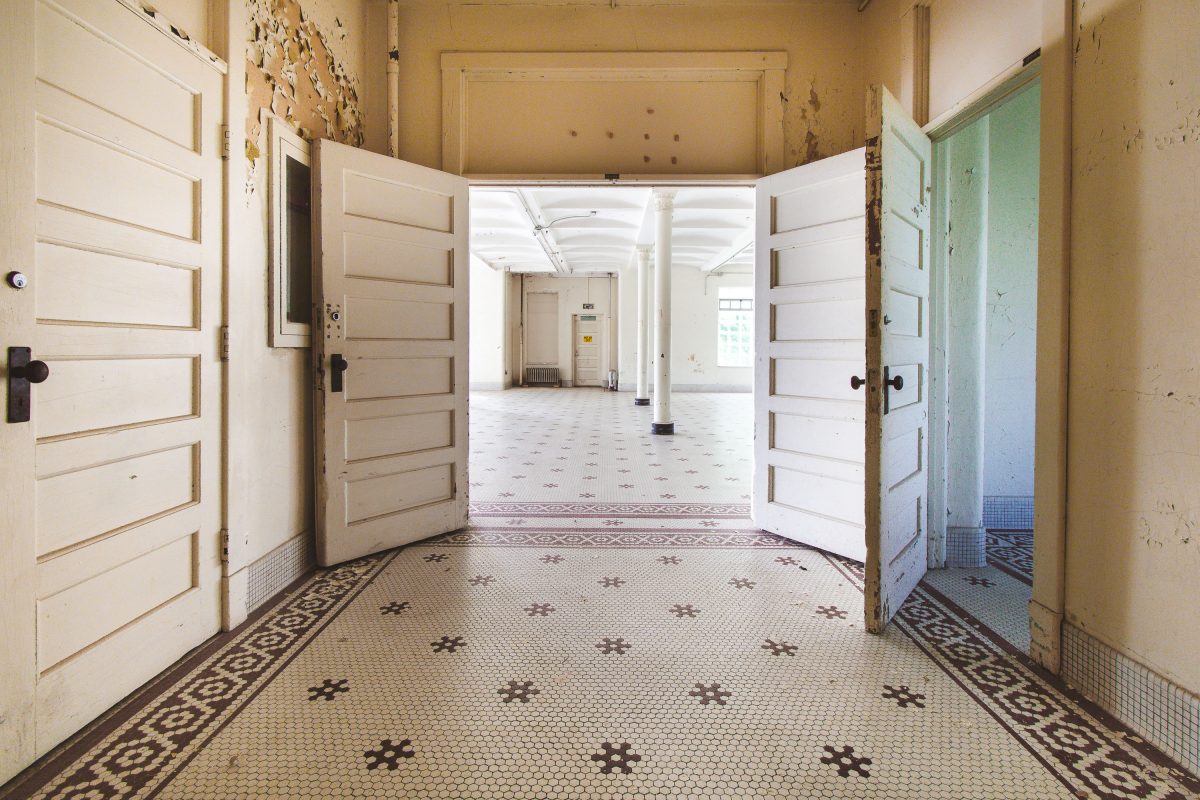 Double doors opening onto hexagonal tile hallway, Fergus Falls Kirkbride Building