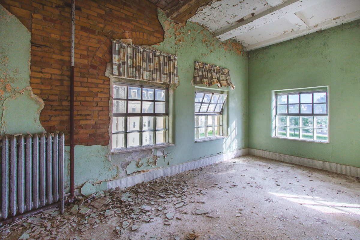 Exposed brick patient room with radiator, Fergus Falls Kirkbride Building