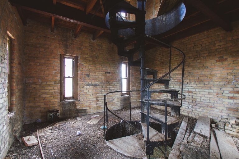 Spiral Staircase in Brick Tower Room, Fergus Falls Kirkbride Building 1 Spiral metal staircase with railings in brick interior room at Eagle Island psychiatric hospital.
