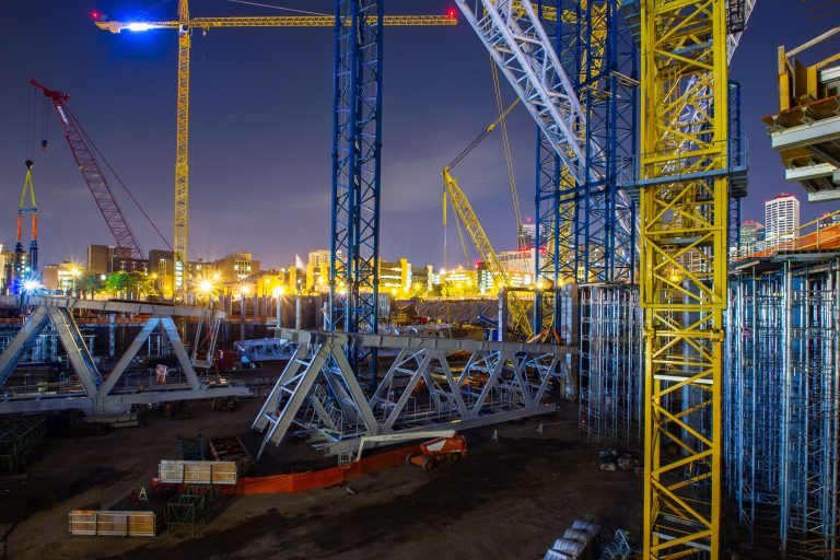 Tower Cranes at US Bank Stadium Construction Site, Minneapolis 4 Construction cranes and structural steel framework at the US Bank Stadium site in downtown Minneapolis at dusk.