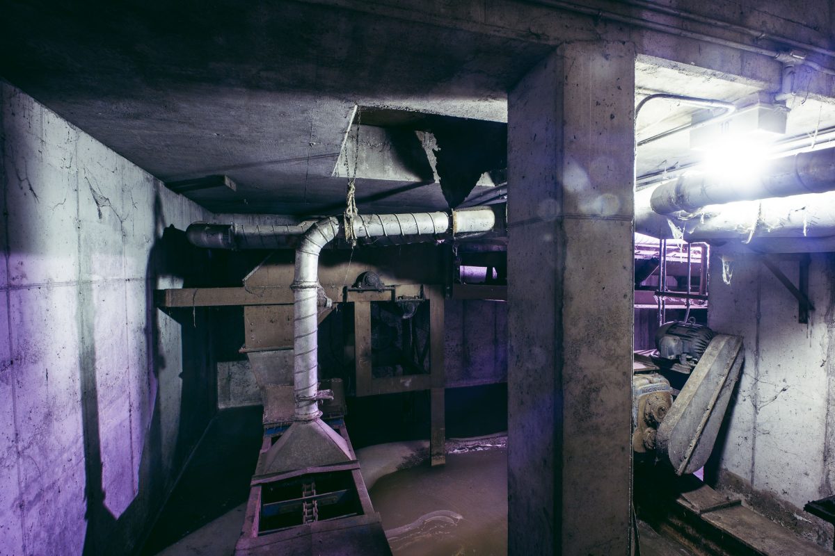 Interior of Upper Harbor Terminal barge facility showing concrete structure, metal piping, and industrial equipment.