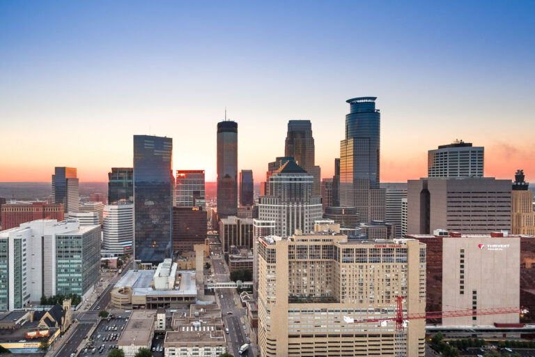 Minneapolis Downtown Buildings at Sunset 1 Minneapolis downtown buildings, including IDS Center and Capella Tower, illuminated by sunset. The city's commercial and cultural hub in Minnesota.