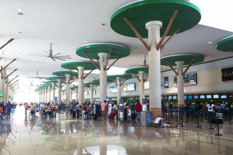 Punta Cana International Airport Departure Hall Architecture 1 The departure hall of Punta Cana International Airport (PUJ) in the Dominican Republic features modern architecture with columns supporting circular canopies, evoking palm trees.