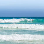 A surfer at Playa Macao in Dominican Republic near Punta Cana.