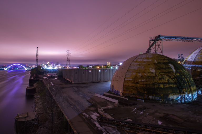 Storage Domes at Upper Harbor Terminal Overlooking the Lowry Bridge 2 Abandoned barge terminal on the Mississippi River in Minneapolis at dusk, with industrial domes and loading equipment visible.