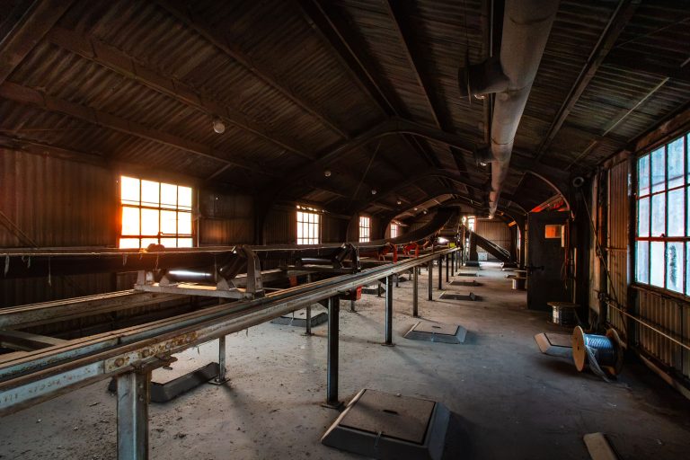 Conveyor Belt Inside the Electric Steel Elevator in Minneapolis 4 Abandoned warehouse interior with steel conveyor systems and industrial machinery lit by windows.