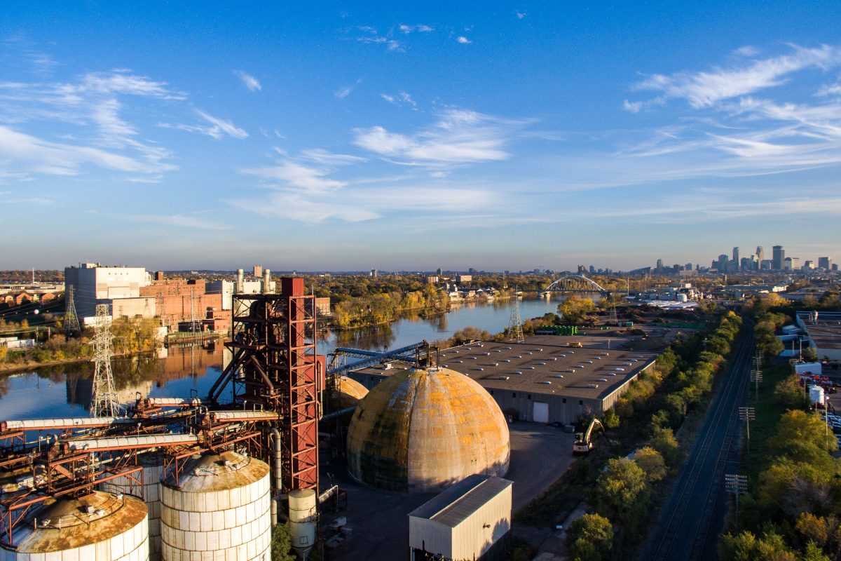 Upper Harbor Terminal, a former barge facility on the Mississippi River in north Minneapolis, sits idle with storage tanks and industrial structures visible.