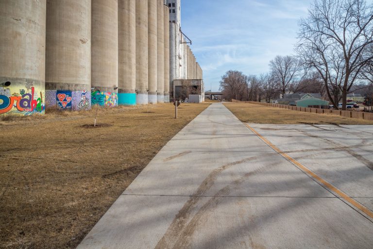 Grain Elevator Silos Along South Omaha Trail 1 Paved South Omaha Trail runs beside painted concrete grain elevator silos in Omaha, Nebraska.