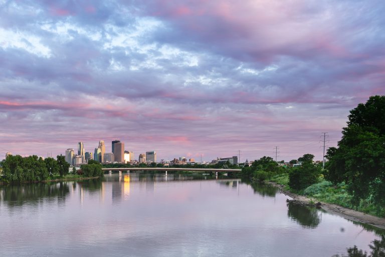 View of Minneapolis Skyline from the north side 3 Minneapolis skyline beyond the Mississippi River under evening clouds.