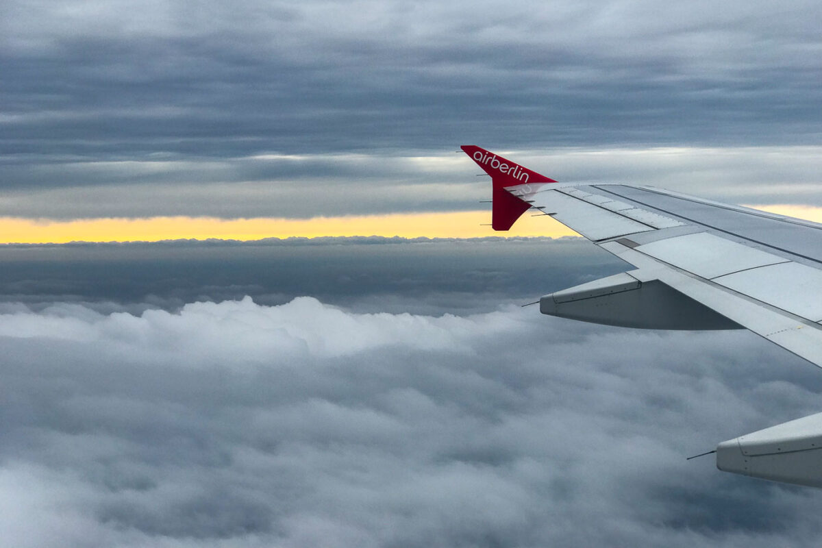 Looking out the window at the wing of an airplane with Air Berlin logo painted on it.