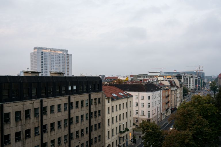 Charité Tower Above Invalidenstraße Rooftops, Berlin 1 Rooftop view of Berlin's Invalidenstraße with the Charité hospital tower rising above surrounding apartment buildings.