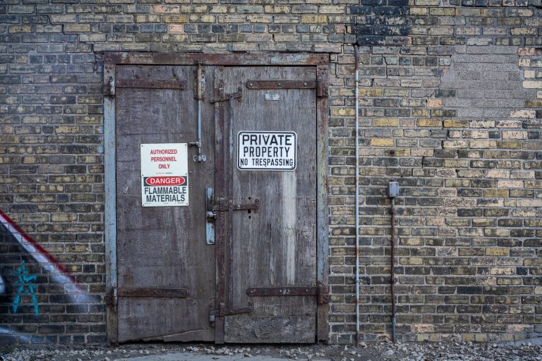 Loading Dock, Viterra Grain Elevator, Minneapolis 2 Weathered industrial door with "Private Property" and "Flammable Materials" warning signs on brick wall.
