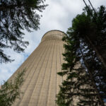 Monceau-sur-Sambre power cooling tower 1 A 118-meter-tall cooling tower stands amid overgrown trees at the former Monceau-sur-Sambre power station near Charleroi, Belgium. Constructed in the 1960s as part of a large coal-fired generating complex operated by Electrabel, the hyperboloid structure was engineered from reinforced concrete with vertical ribbing to support its weight and withstand wind pressure. The tower once cooled thousands of cubic meters of water per hour, discharging excess heat from the station’s turbines that supplied electricity to the industrial Walloon region. Following the plant’s closure in the early 2000s, the site has remained disused, its monumental scale and weathered surface now emblematic of Charleroi’s industrial decline and gradual environmental recovery.