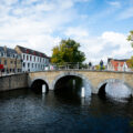 People walking over a bridge in Bruges, Belgium.