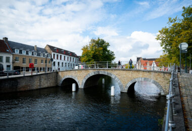 People walking over a bridge in Bruges, Belgium.