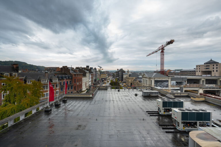 Rue de Fer, Namur: Station Approach and Crane 1 A construction crane is visible over Rue de Fer in Namur, Belgium, a street leading to the city's main railway station, with a mix of historic and modern architecture.