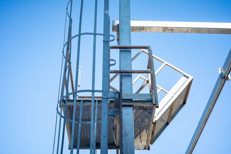 Safety Cage and Platform, Viterra Grain Elevator, Minneapolis 1 Grain elevator industrial structure with blue metal framework and access platform against clear sky.