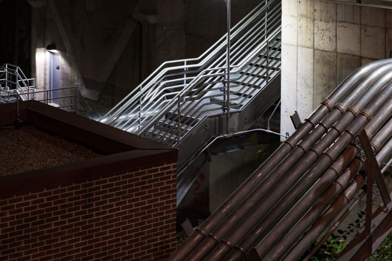Steam Pipes and Stairwell, Main Energy Plant, University of Minnesota 4 Industrial pipes and metal staircase at University of Minnesota's Main Energy Plant facility.