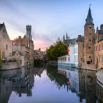 Rzenhoedkaai canal view, with the Belfry of Bruges (Belfort) visible in the background.