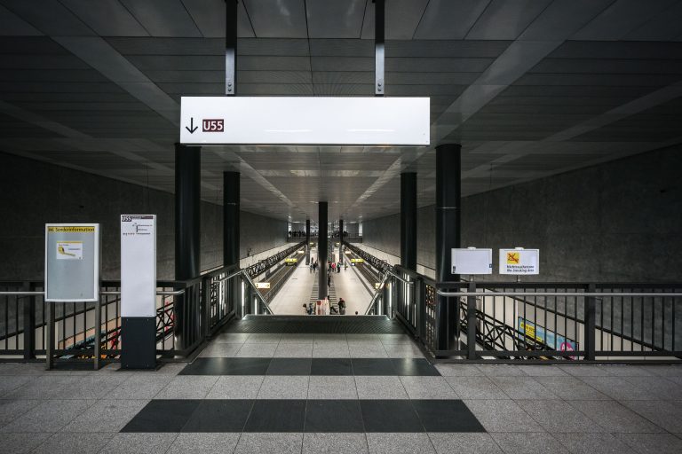 U55 Platform, Berlin Hauptbahnhof 1 Underground U55 platform at Berlin Hauptbahnhof with symmetrical staircases and escalators leading to train tracks.