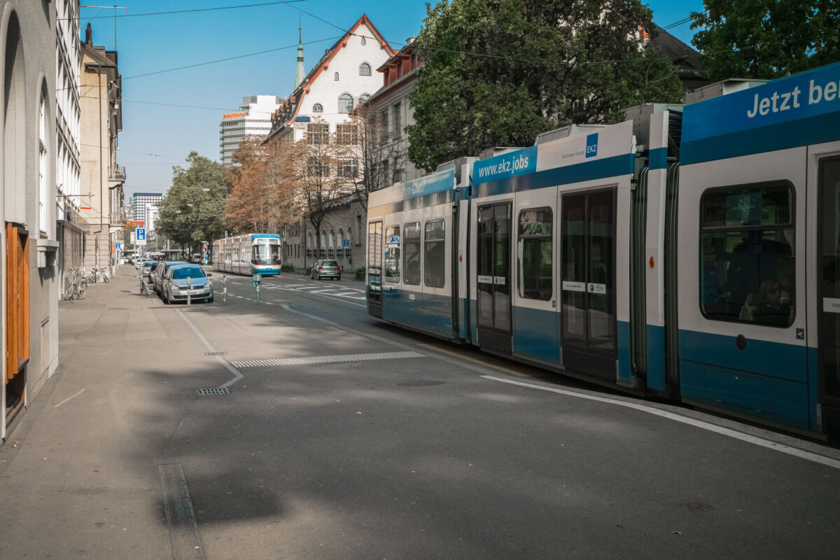 Two VBZ trams on a tree-lined avenue in Zurich, Switzerland. The city's tram network, established in the 1880s, is a key part of its urban mobility.
