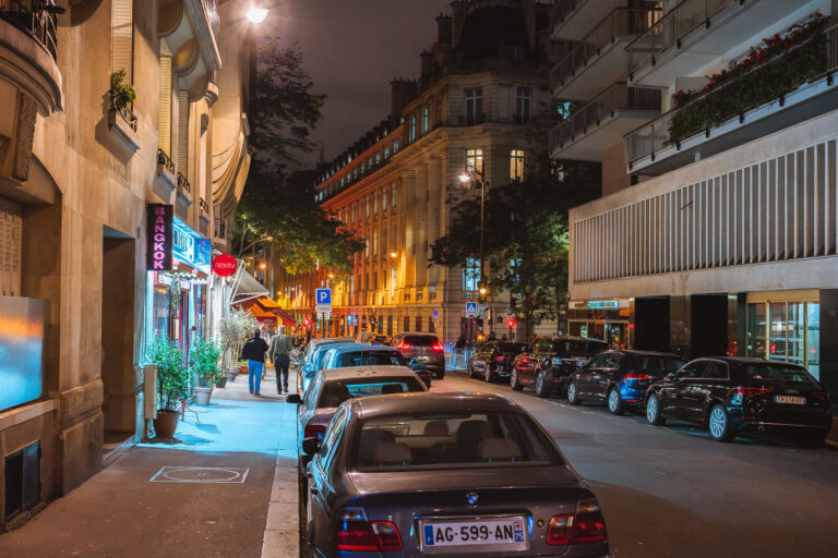 Bangkok Restaurant on Paris Street at Night 1 A "Bangkok Restaurant" sign is illuminated at night on a street in Paris, France, in October 2017. Cars are parked along the curb of the urban thoroughfare.