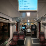 An early morning S-Bahn train heads toward Zürich Hauptbahnhof, Switzerland’s busiest railway hub. The interior, illuminated by soft fluorescent lighting and digital displays, reflects the precision and cleanliness that define Swiss rail travel. With clearly marked stops and ergonomic seating, the S-Bahn system connects Zürich’s suburbs to the city center with remarkable efficiency and punctuality.

The Zürich S-Bahn network began operation in 1990 as one of Europe’s first regional rail systems to integrate multiple operators under a unified timetable. Zürich HB serves as its central interchange, handling over 400,000 passengers daily and linking regional, national, and international routes. This modernization transformed local commuting and reinforced Switzerland’s reputation for world-class rail infrastructure.