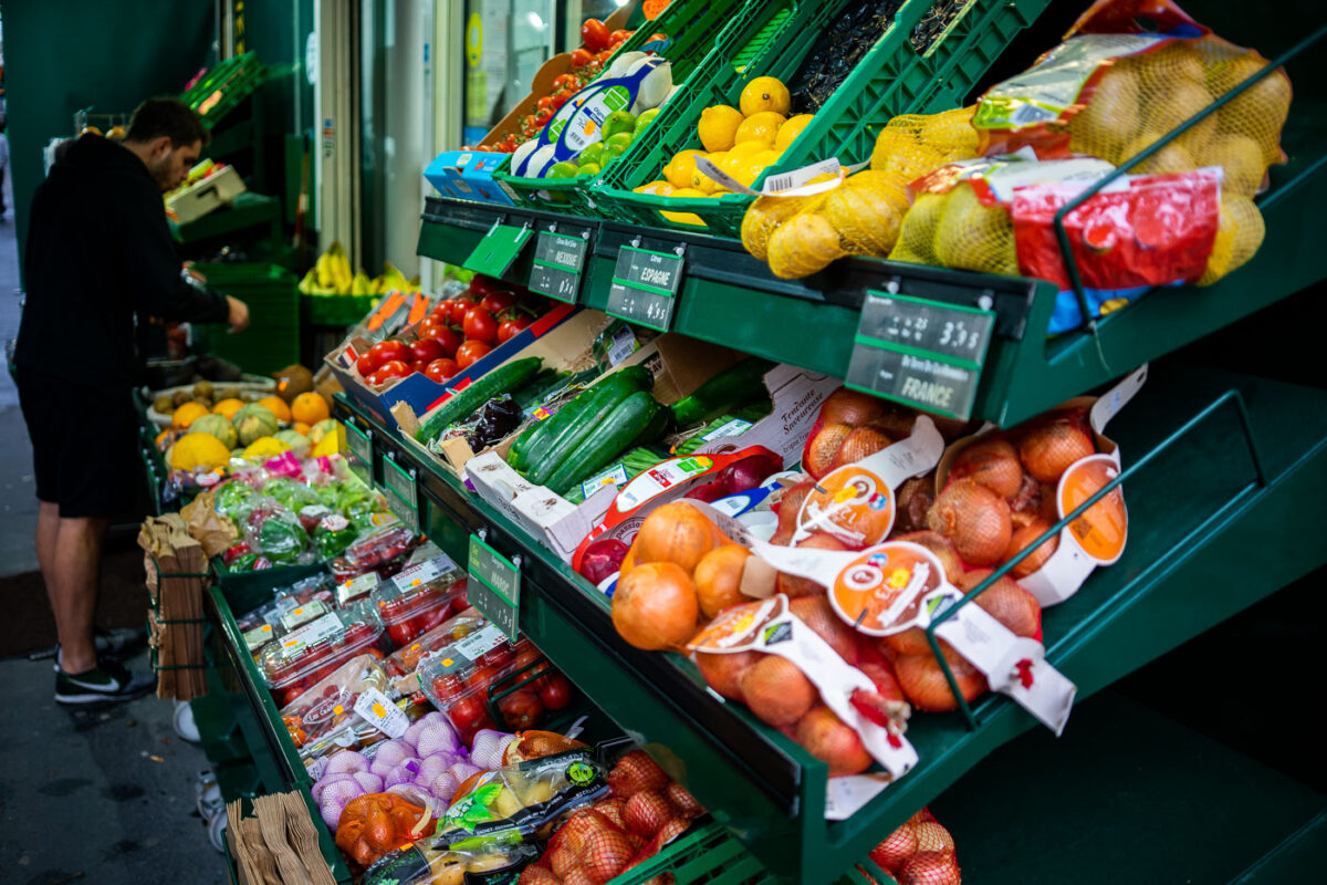 A man shops at a market in Paris, France.