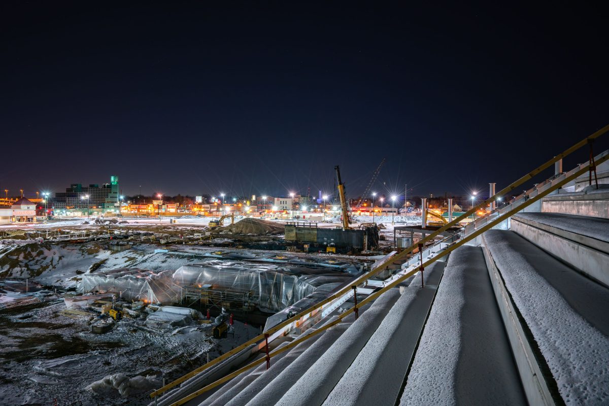 Nighttime construction site for Allianz Field stadium in St. Paul with industrial infrastructure and city lights.