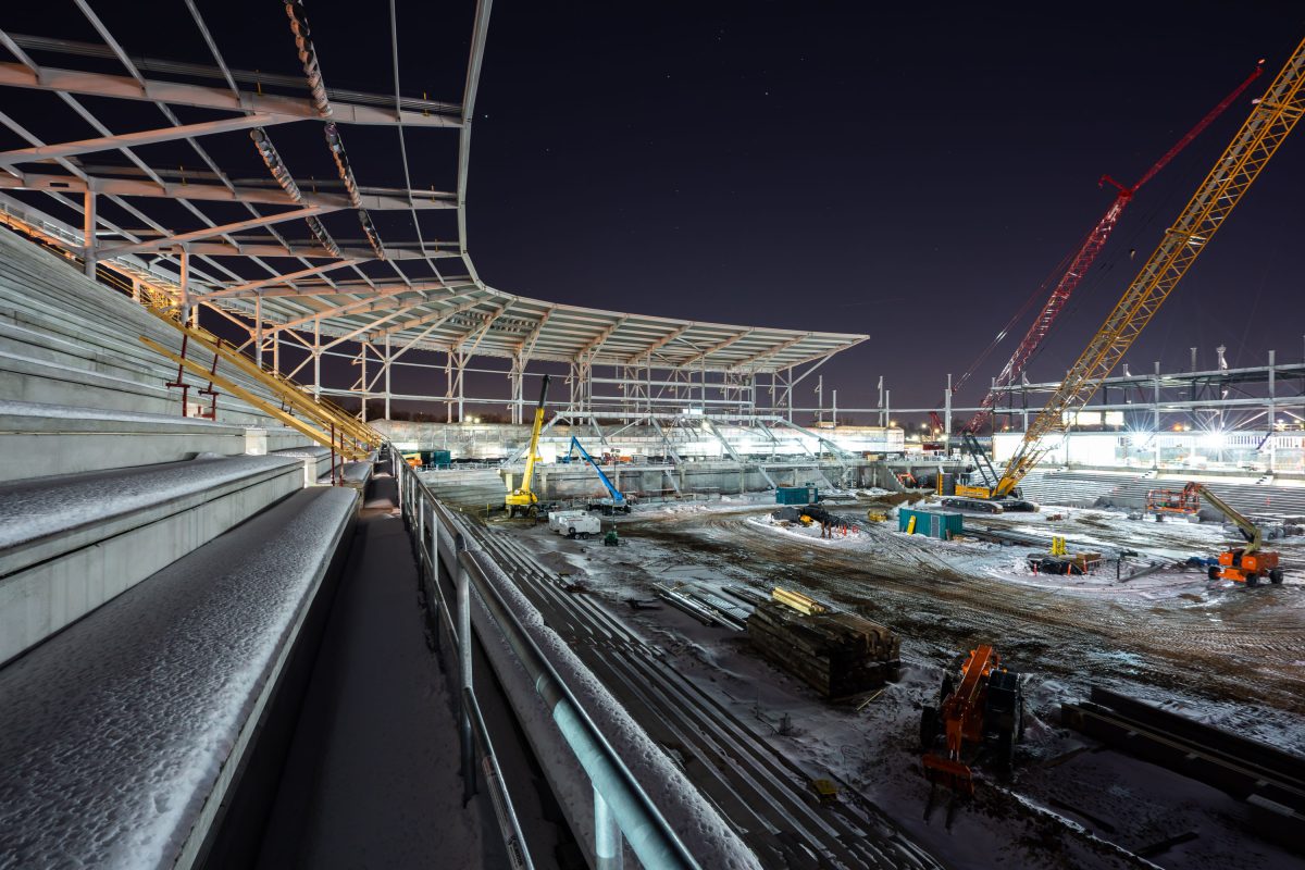 Nighttime construction of Allianz Field stadium in St. Paul with steel framing and cranes.