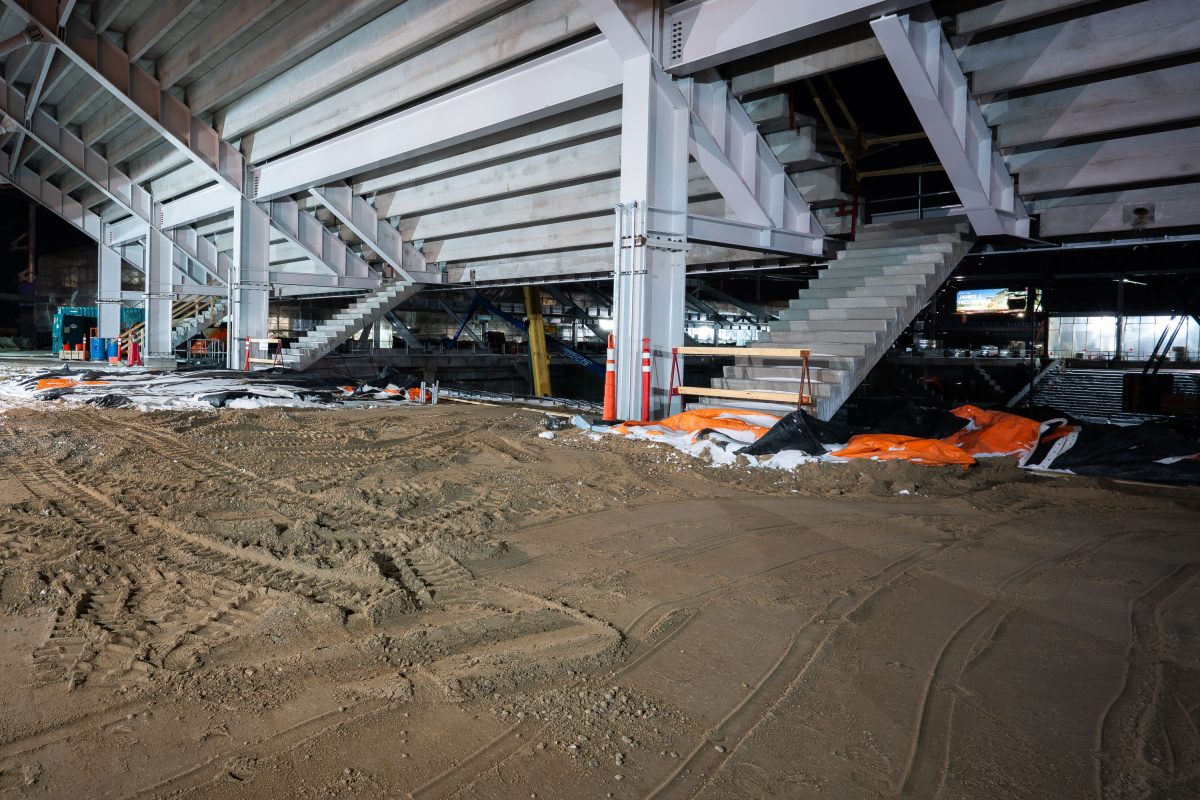 Allianz Field stadium under construction in St. Paul showing excavated dirt floor and white steel framework.