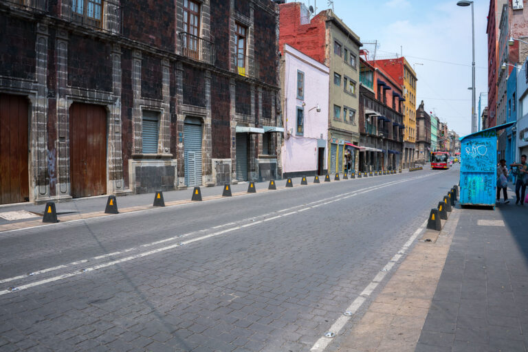 Calle República de Uruguay in Mexico City’s Historic Core 1 Calle República de Uruguay in the heart of Mexico City’s Centro Histórico, lined with colonial-era stone façades and early 20th-century buildings showing layers of renovation and age. The street, paved with basalt cobblestones, reflects the city’s dense architectural history where 18th-century walls coexist with modern storefronts and utilities. The corridor connects the Zócalo area with Eje Central, serving as one of the oldest commercial arteries in the capital.