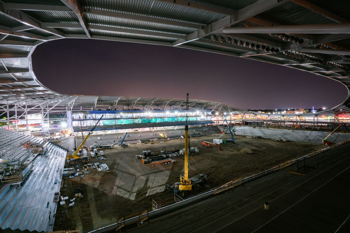 Allianz Field stadium construction site in St. Paul at night with excavated ground and steel framework.