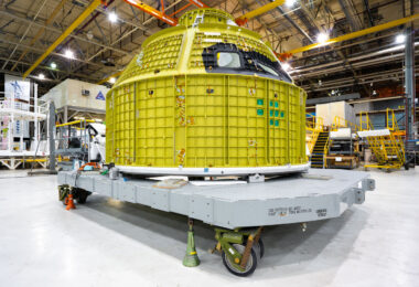 The Orion spacecraft’s crew module sits on a transport platform at NASA’s Michoud Assembly Facility in New Orleans, Louisiana. Built by Lockheed Martin, this pressure vessel is the primary structure that will house astronauts during Artemis missions to the Moon. The aluminum-lithium frame, painted in primer yellow, is designed to withstand both launch forces and the harsh conditions of deep space. Each module undergoes precision assembly and testing at Michoud before being shipped to Kennedy Space Center for outfitting and integration with the Space Launch System rocket.