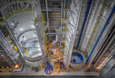 A high-angle view inside NASA’s Michoud Assembly Facility in New Orleans shows the enormous vertical welding and assembly bays used to build sections of the Space Launch System (SLS) rocket. The towering circular structure on the left is part of the Vertical Weld Center, where cylindrical rocket segments are precisely joined using friction-stir welding. Catwalks and access platforms ring the interior, supporting technicians during construction of the world’s most powerful launch vehicle for the Artemis program.