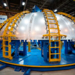 Inside NASA’s Michoud Assembly Facility in New Orleans, a massive aluminum dome section undergoes welding using a PAR Systems I-Stir Friction Welder — a precision tool developed for joining thick aerospace materials without melting them. This technique, essential for spacecraft and fuel tank construction, uses frictional heat and mechanical pressure to create exceptionally strong, defect-free joints. Boeing engineers employ the system for the assembly of rocket and space vehicle components, part of a long legacy of large-scale fabrication at Michoud dating back to the Saturn V and Space Shuttle programs.