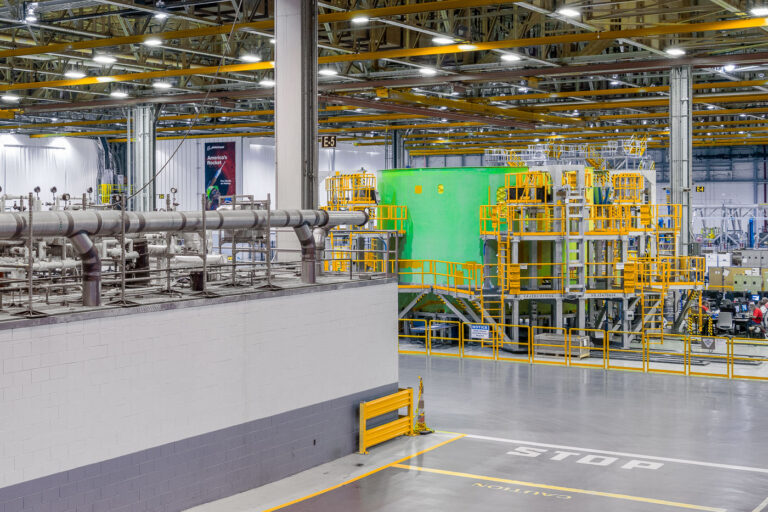 Core Stage Manufacturing Area at NASA Michoud Assembly Facility 4 Inside the cavernous NASA Michoud Assembly Facility in New Orleans, the green-painted structure of a Space Launch System (SLS) rocket component dominates the factory floor. Surrounded by yellow access platforms and intricate piping, this section is part of the massive tooling infrastructure used to assemble and test rocket core stages. Overhead cranes and precision systems support Boeing’s production of “America’s Rocket,” with each stage destined for integration into NASA’s Artemis program to return humans to the Moon.