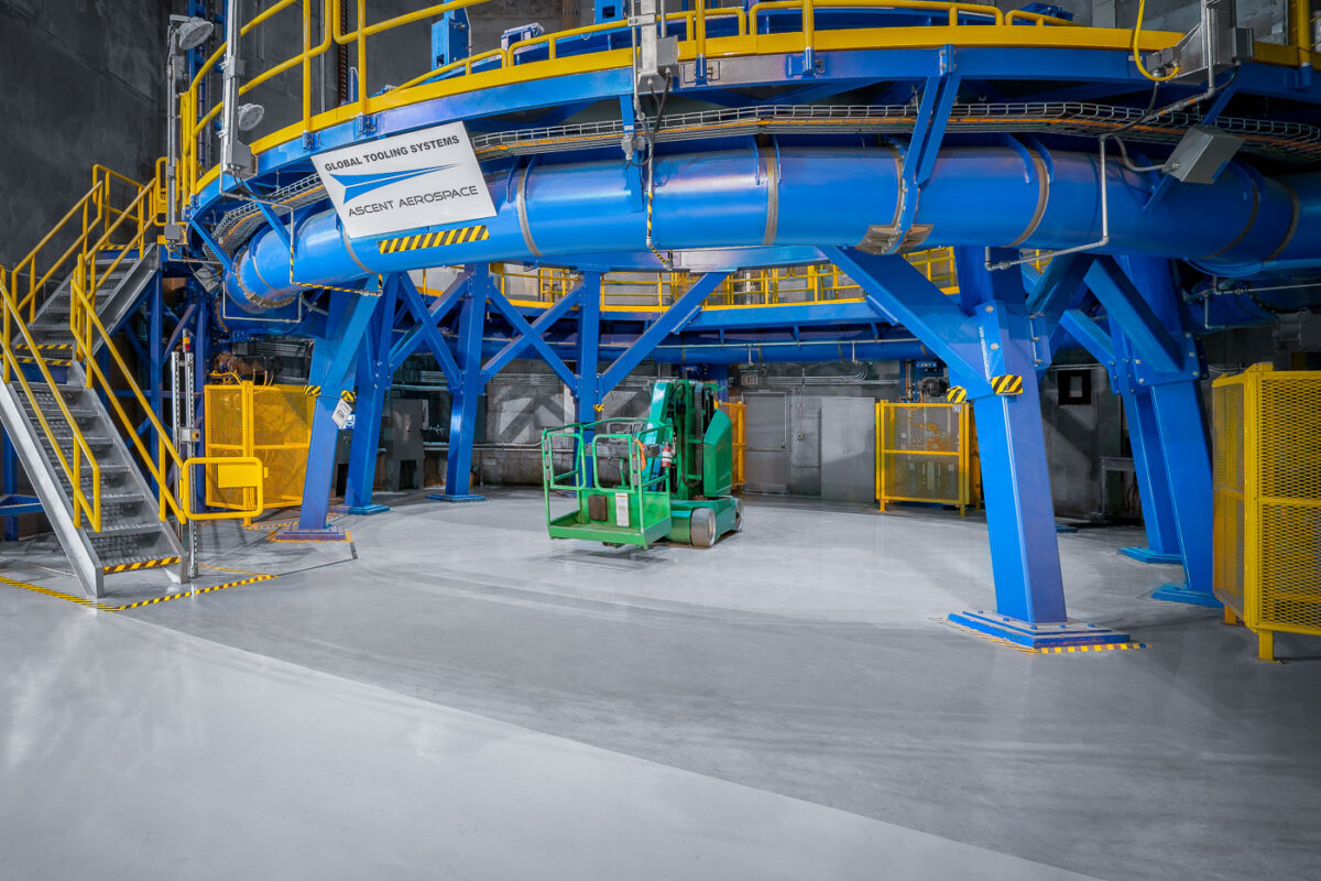 Tooling Platform at NASA Michoud Assembly Facility 1 A bright blue and yellow tooling structure dominates this section of NASA’s Michoud Assembly Facility in New Orleans. Built by Ascent Aerospace’s Global Tooling Systems division, this heavy-duty platform is part of the specialized infrastructure used to assemble components of the Space Launch System (SLS) rocket. The steel frame supports massive cylindrical sections during alignment and welding, forming part of the precision manufacturing ecosystem that enables Artemis missions to take shape from the ground up.