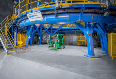 A bright blue and yellow tooling structure dominates this section of NASA’s Michoud Assembly Facility in New Orleans. Built by Ascent Aerospace’s Global Tooling Systems division, this heavy-duty platform is part of the specialized infrastructure used to assemble components of the Space Launch System (SLS) rocket. The steel frame supports massive cylindrical sections during alignment and welding, forming part of the precision manufacturing ecosystem that enables Artemis missions to take shape from the ground up.