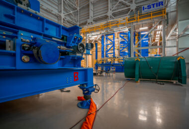 Inside NASA’s Michoud Assembly Facility in New Orleans, the Vertical Weld Center is shown — a precision friction-stir welding system used to join the massive aluminum alloy panels that form rocket fuel tanks and core stages for the Space Launch System. The bright blue and yellow structures are part of the tooling system that ensures millimeter-level accuracy during assembly, critical for the Artemis program’s deep space missions.